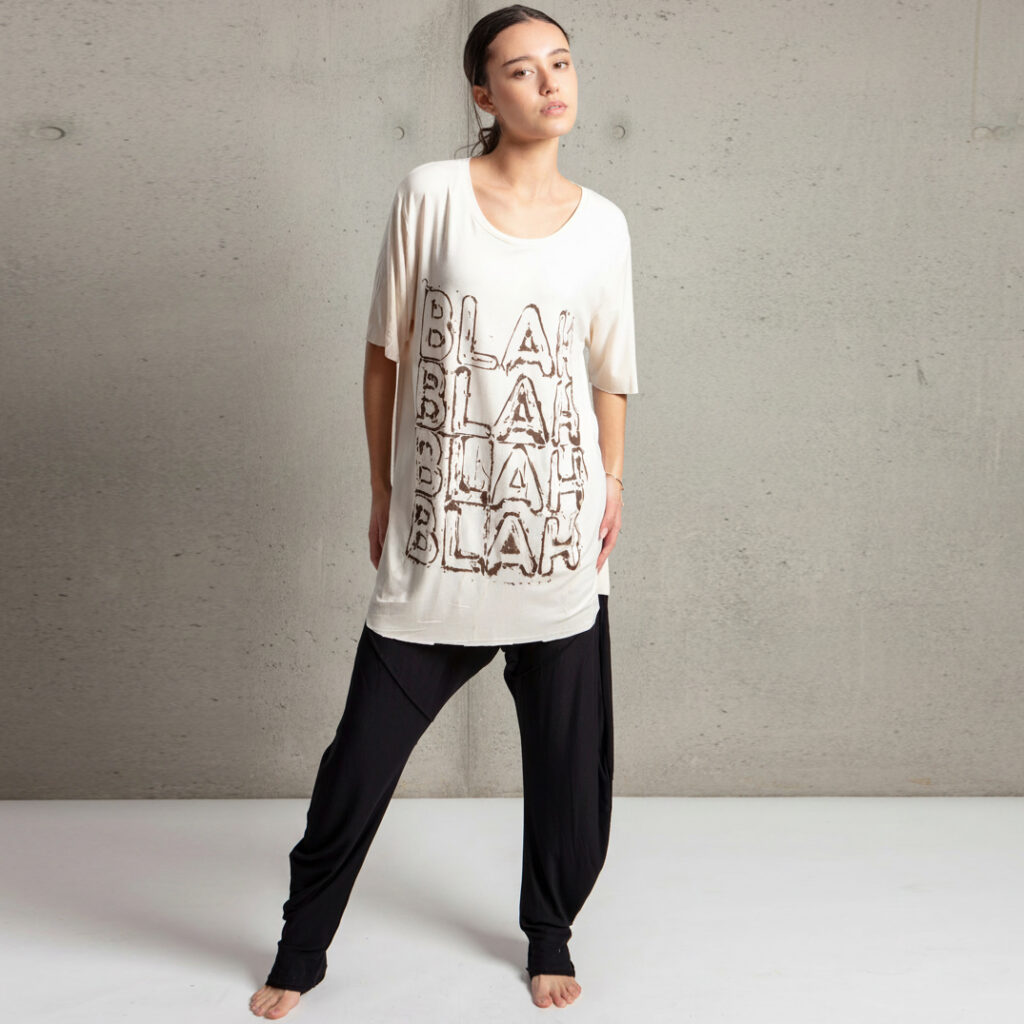 Female model wearing Graffi t-shirt and lightweight pants in an industrial loft setting